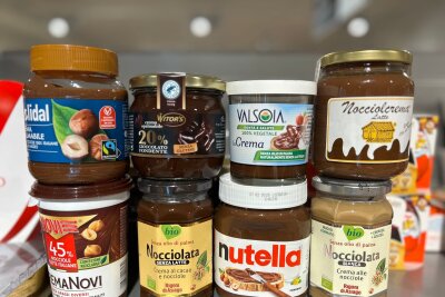 Die, der, das, mit oder ohne? Nutella wird 60 - Gläser mit verschiedenen Nuss-Nougat-Aufstrichen in einem italienischen Supermarkt.