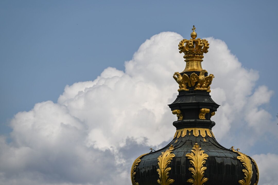 Maifeiertag in Sachsen wird sonnig - Wolken ziehen hinter dem Kronentor des Dresdner Zwingers am Himmel auf.