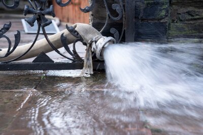 3 Versicherungen, die Immobilienbesitzer unbedingt brauchen - Wasser abpumpen nach einer Flut: Eine Wohngebäudeversicherung muss jeder Immobilienbesitzer haben.