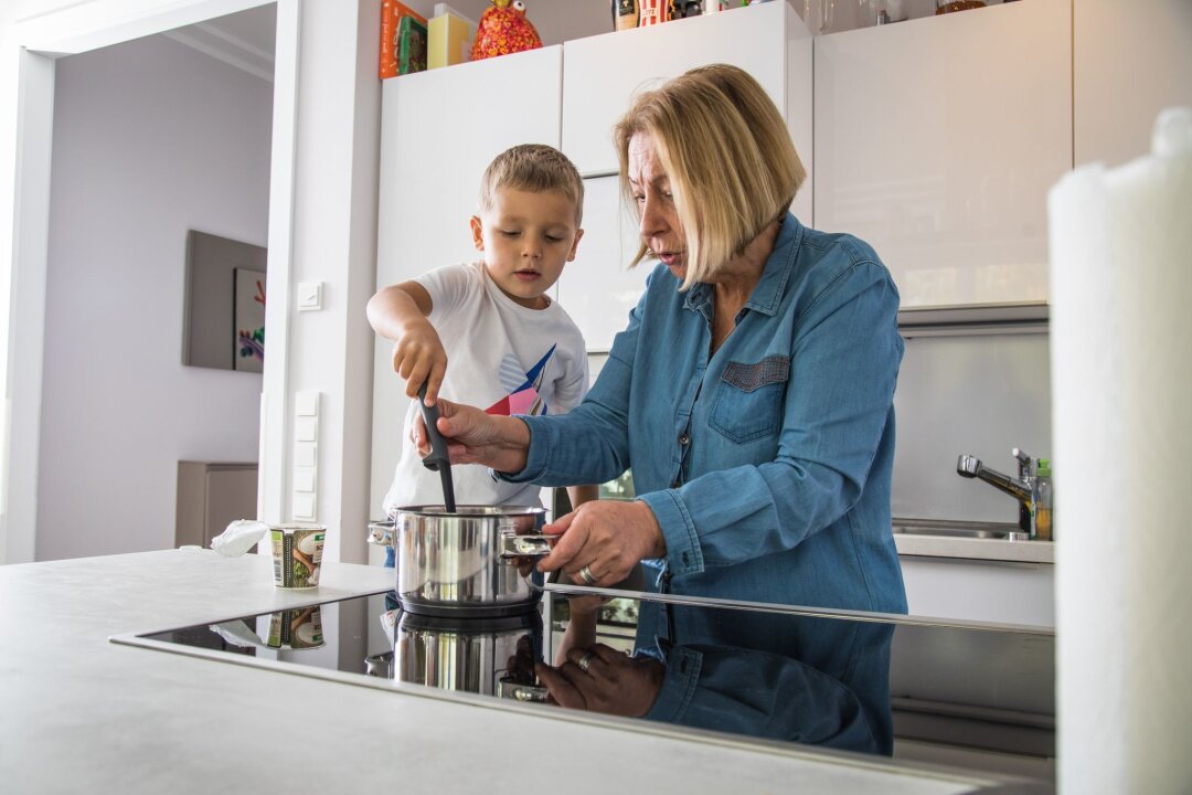 4 Tipps, die kleine Kinder vor Verbrühungen bewahren - Beim gemeinsamen Kochen ist Vorsicht geboten: Heiße Töpfe und spritzende Flüssigkeiten können schnell zu Verbrühungen führen.