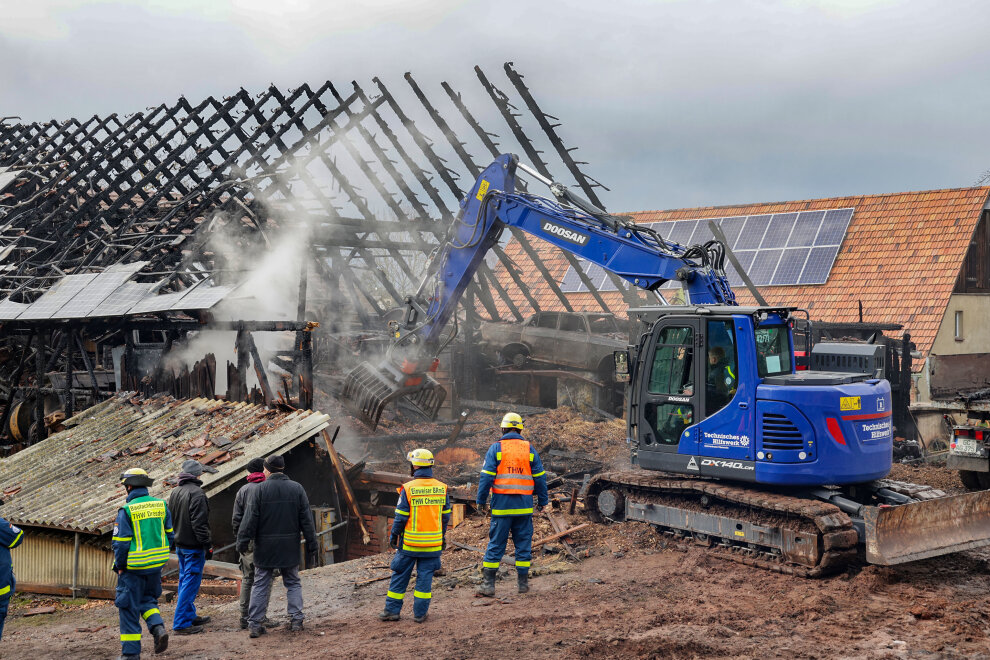 Das THW ist seit etwa 13 Uhr mit einem Bagger im Einsatz, um das abgebrannte Gebäude abzureißen. Foto: Andreas Kretschel