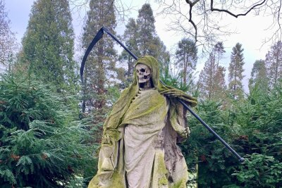 Ausflugsziel Friedhof: Diese Ruhestätten lohnen einen Besuch - Der Sensenmann ist ein beliebtes Fotomotiv auf dem Kölner Melaten-Friedhof.