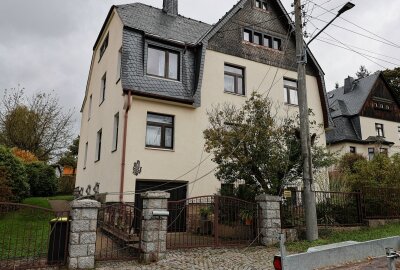 Baum fällt auf Garage: Person verletzt und Stromleitungen beschädigt - Ein entwurzelter Baum liegt auf einer Doppelgarage in Lößnitz, nachdem er durch den Sturm gefallen ist und Stromleitungen mitgerissen hat. Foto: Niko Mutschmann 