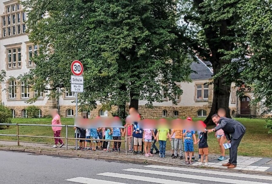 Besondere Unterrichtsstunde: Sicher im Straßenverkehr - Nicky Scholz, Fachabteilungsleiter Fahrerlaubniswesen, der DEKRA-Niederlassung Chemnitz, hat die Erstklässler der Grundschule Rabenstein über das richtige Verhalten an einem Fußgängerüberweg informiert. Foto: Annika Engelmann/DEKRA Chemnitz