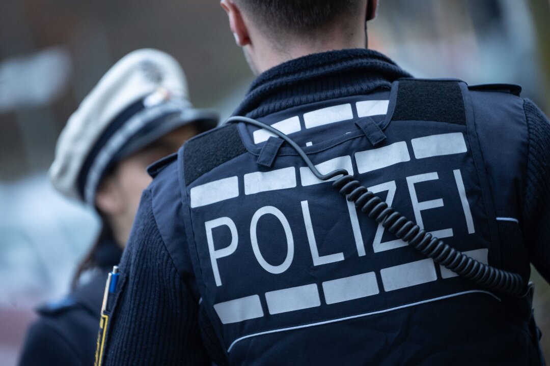 Betrug um 113 Millionen Euro: Sechs Verdächtige festgenommen - Eine Polizistin (l) und ein Polizist gehen eine Straße entlang.
