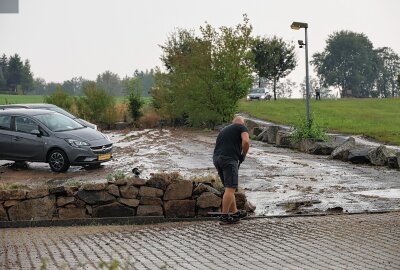 Blitzeinschlag in Lößnitz - Schlamm über Straße in Schwarzenberg - Diese verteilten sich erst auf einem Autohaus-Parkplatz, dann auf der Auer Straße und schließlich in mehreren Vorgärten. Foto: Niko Mutschmann