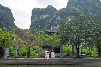 Bootstour durch's Welterbe: Im Delta des Roten Flusses - Suối Tiên-Tempel: Ein paar Stufen führen zu dem palastartigen Holzbau mit Pagodendach, in dessen Innerem Besucher vor verzierten goldenen Statuen knien und beten. 