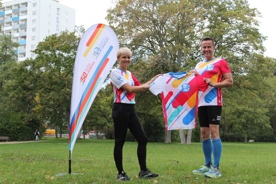 Chemnitzer Entscheider auf Marathon-Kurs: Erste Trainingseinheit absolviert - Verena Heinze, Bereichsleiterin Gesamtbanksteuerung der Sparkasse Chemnitz, und Dr. Michael Kreuzkamp, Vorstandsvorsitzender der Sparkasse Chemnitz, stellen das offizielle Laufshirt vor.