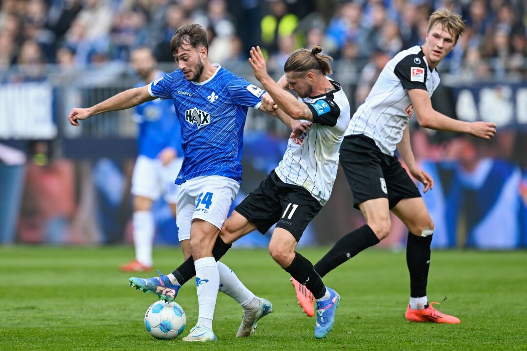 Darmstadt 98 kommt nicht über 1:1 gegen Ulm hinaus - Darmstadts Killian Julian Corredor (l) und Ulms Dennis Chessa kämpfen um den Ball.