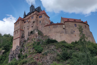 Burg Kriebstein mit Abhang und leicht bewölktem Himmel