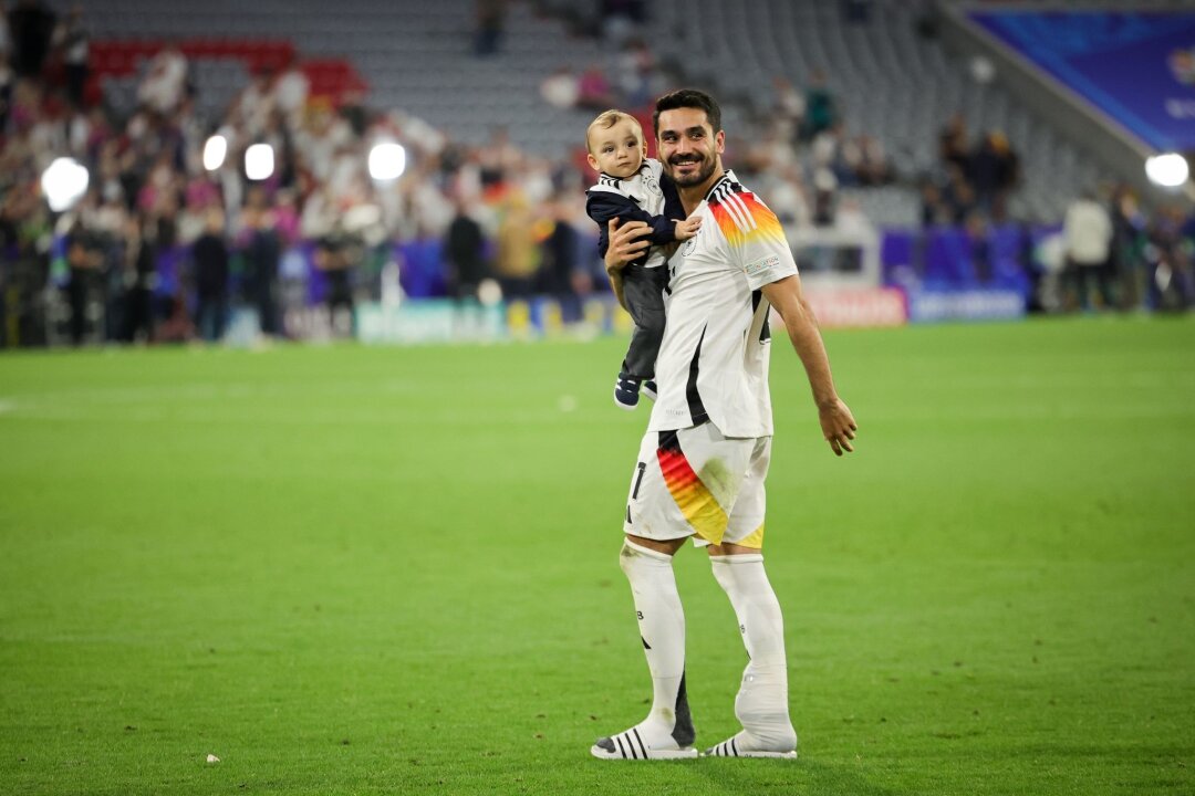 Der "Bessermacher" liefert: Gündogan zeigt's den Zweiflern - DFB-Kapitän Ilkay Gündogan geht nach dem Spiel gegen Schottland mit seinem Sohn auf dem Arm über den Platz.