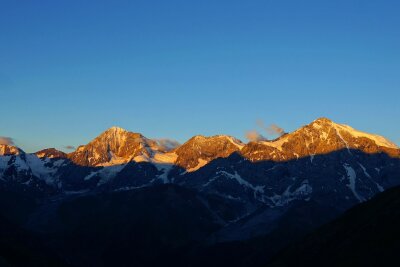 Downhill, kiten, fliegen: Aktivurlaub im Vinschgau - Sonnenaufgang über dem 3.905 Meter hohen Ortler in Südtirol - der Ortler Höhenweg führt rund um das gewaltige Bergmassiv.