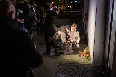 Drei Tote in Berliner Wohnung - Verdacht auf Tötungsdelikt - Anwohner legen Blumen und Kerzen nieder. 