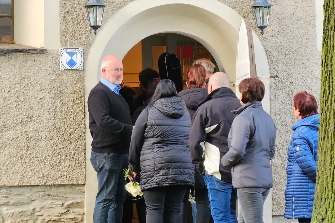 Drei Tote in Tirpersdorf: Einwohner suchen in Andacht Halt - Pfarrer Tilo Kirchhoff (l) begrüßt Teilnehmer der Andacht vor der evangelischen Kirche Tirpersdorf.