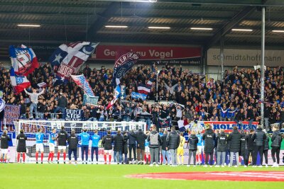 Eine Cola-Zero und ein Trikot fürs Kieler Vereinsmuseum - Kiels Spieler feiern mit den Fans den Sieg.