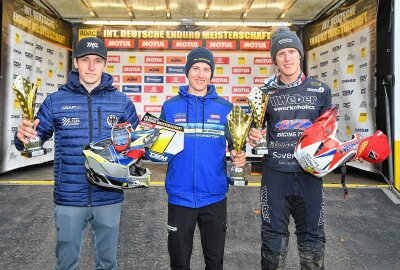 Enduro "Rund um Zschopau" bittet zum Tanz - Da fühlt sich Jeremy Sydow am wohlsten - in diesem Jahr wie immer bei den Siegerehrungen in der Mitte, in diesem Fall zwischen Luca Fischeder (li.) und Davide von Zitzewitz (re.). Foto: Thorsten Horn