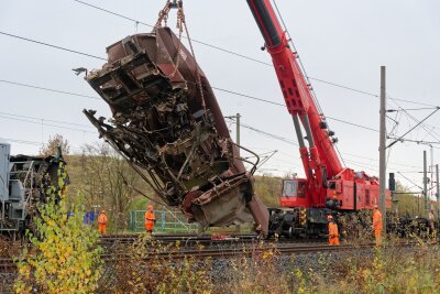 Entgleister Zug bei Köln - Bergung beginnt - Ein schwerer Kran hob einen ersten Güterwaggon von den Gleisen und stellte ihn neben den Schienen ab.