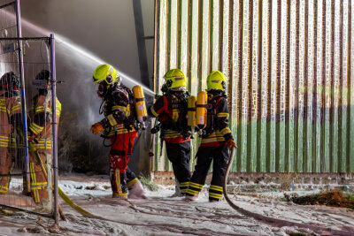 Erneuter Brand in Lagerhalle: War es Brandstiftung? Schriftzug gibt Rätsel auf - 100 Kameraden der Feuerwehren aus Neumark und Umgebung kämpften gegen die Flammen an.