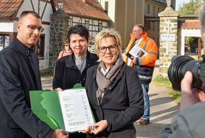 Errichtung einer Gedenkstätte für das ehemalige KZ Sachsenburg startet - Kultusministerin Barbara Klepsch ( rechts) übergibt Bürgermeister Oliver Gerstner den Fördermittelbescheid im Beisein von Landtagsabgeordneten, Museumsexperten und Planungsfachleuten. Foto: Christof Heyden