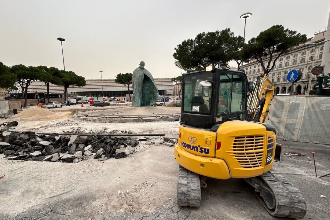 Ewige Baustelle - Rom leidet vor "Heiligem Jahr" - Der bronzene Papst Johannes Paul II. vor dem Hauptbahnhof blickt auf einen aufgerissenen Boden.