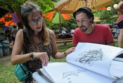 Festival "Stains in the Sun" hat buntes Programm geboten - Besucherin Natalie Bödger aus Schwarzenberg (li.) und Max Krätzschmar vom Vereinsvorstand (re.) bei der Motivauswahl zum Siebdruck. Foto: Ralf Wendland