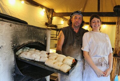 Gaumenfreuden und mehr beim Mittelaltermarkt auf Burg Mylau - Thomas Martini holt das Handbrot aus dem Ofen. Juliane Schönbeck verkauft es dann. Foto: Simone Zeh