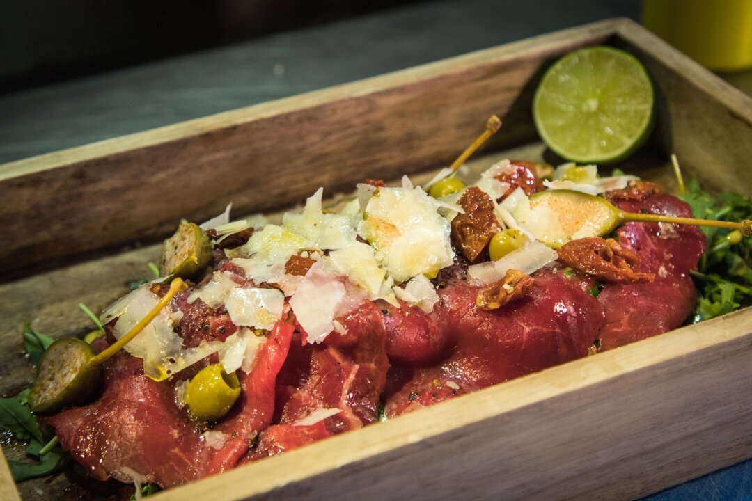 Gerollt oder als Gebirge: Carpaccio modern interpretiert - Statt auf dem runden Teller wird das Carpaccio im "The Dry Gin and Beef Club" auf einem kleinen Tablett auf Rucola angerichtet. Limette träufelt der Gast zum Schluss selbst darüber. 