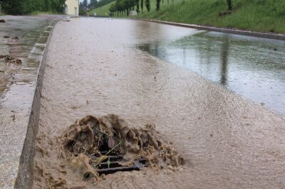 Starkregen sorgt für kleine Bäche auf den Straßen. Foto: Erik Hoffmann