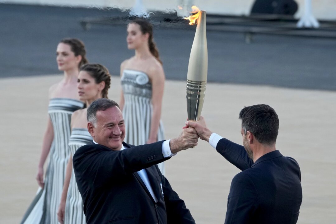 Griechen übergeben olympisches Feuer an Paris - Der Präsident des französischen Organisationskomitees, Tony Estanguet (r), nahm die olympische Flamme in Athen entgegen.