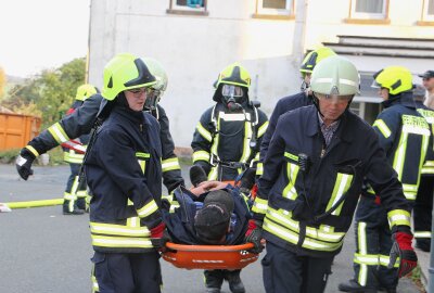 Großen Feuerwehraufgebot an ehemaliger Schule im Vogtland: Was steckt dahinter? - Einer der Vermissten aus dem Haus wird auf der Trage liegend geborgen. Foto: Simone Zeh