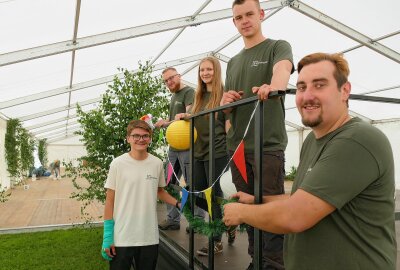 Grünhainichen schmückt sich fürs Heimatfest - Mitglieder des Grünhainichener Jugendclubs helfen beim Schmücken des Festzelts. Foto: Andreas Bauer