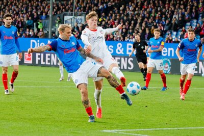 Historisch: Holstein Kiel feiert ersten Bundesliga-Sieg -  Kiels Tymoteusz Puchacz (l) und Heidenheims Paul Wanner kämpfen um den Ball.