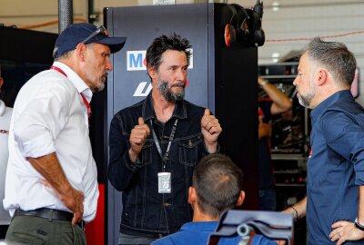 Hollywood-Star Keanu Reeves zu Gast beim Grand Prix am  Sachsenring - Motorrad Grand Prix Sachsenring 2024: Keanu Reeves im Gespräch mit Klaus Kinigardner, Hannes Kinigardner und Jens Hainbach Foto: Nico Schneider