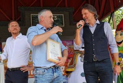 Hunderte Besucher erleben im Freizeitpark Plohn Sachsens größte Schulstart-Party - Junior-Chef Jan Völkel (Mitte) vom Freizeitpark im Gespräch mit Moderator Ingo Dubinski. Sachsens Ministerpräsident hörte gespannt zu. Foto: Thomas Voigt