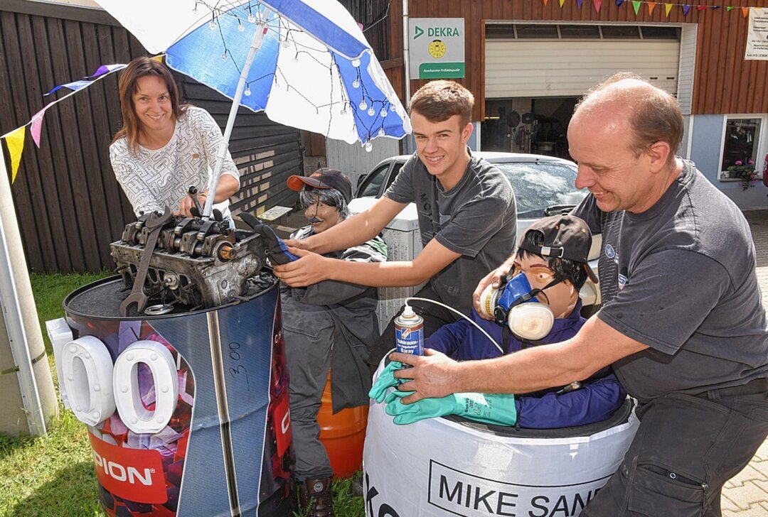 Hunderte urige Typen erobern Dorfchemnitz - In Dorfchemnitz putzen die Einheimischen ihren Ort heraus: Vor ihrer Autowerkstatt bauen Christina, Max und Mario Frohs die Puppenkulisse auf. Foto: Christof Heyden