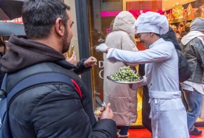 Hype im Lindt-Store Leipzig: Stundenlanges Warten für Dubai-Schokolade - Schokololade für die Wartenden werden verteilt.