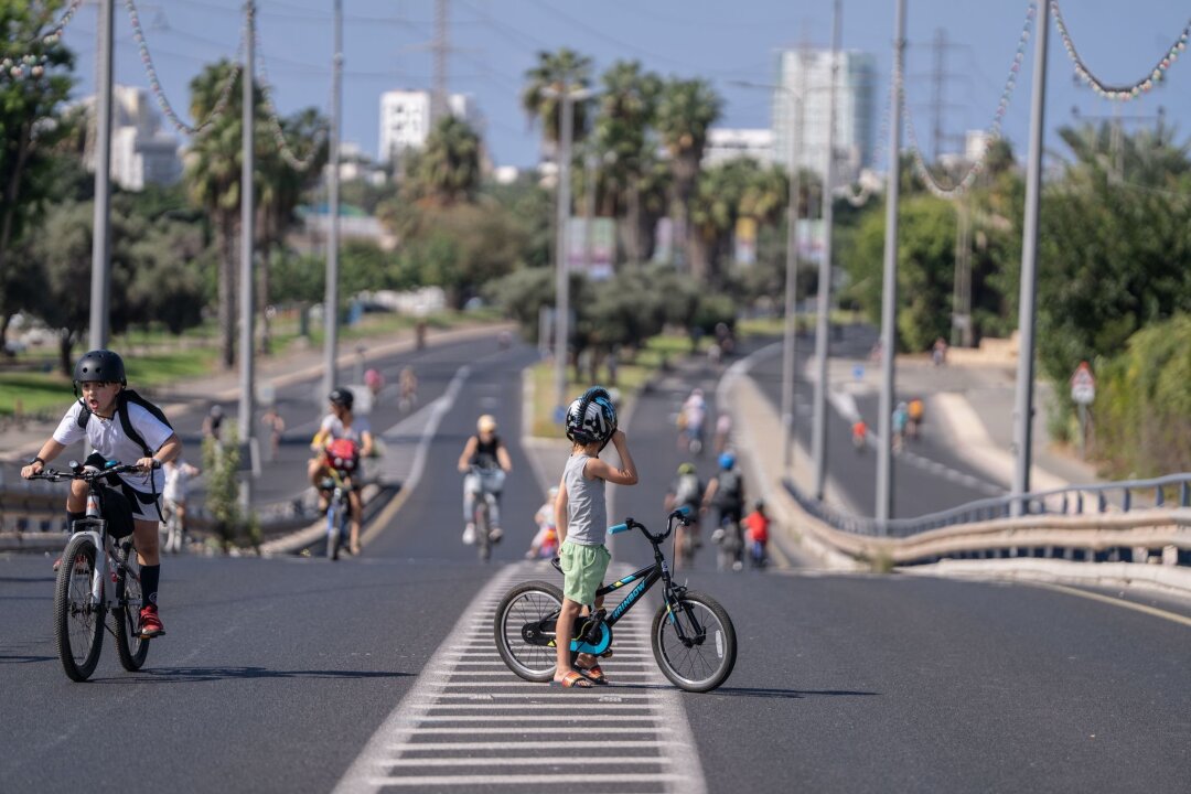 Israel meldet an Feiertag neue Angriffe aus dem Libanon - Menschen in Israel sind mit ihren Fahrrädern auf einer leeren Straße am Feiertag Jom Kippur unterwegs (Foto aktuell).