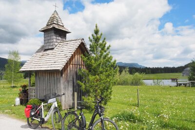 Ja, mir san mit’m E-Bike da: Radrunde durchs Salzkammergut - Saftige Wiesen, Berggipfel und kristallklare Seen sind für den Salzkammergut-Radweg typisch. Und auch sakrale Bauten wie diese Holzkapelle zwischen Bad Aussee und Trautenfels.