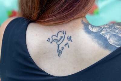 Jasmin (25) aus Berthelsdorf - warum sie eine Uhr ohne Zeiger auf der Haut trägt - Jasmin ließ sich ihr erstes Tattoo mit 18 Jahren stechen. Es war ein kleines Motiv auf dem Rücken, das ihre Liebe zur Musik symbolisiert.