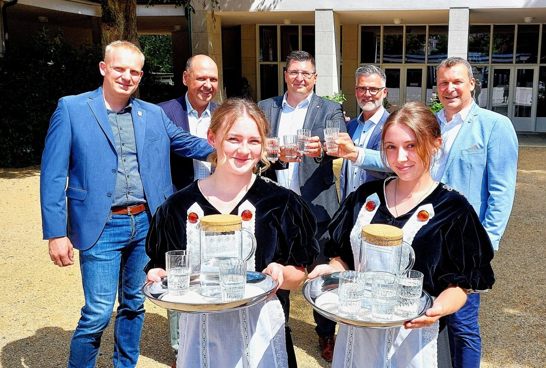 Jubiläum und Tag der Vogtländer: Megaparty in Bad Elster! - Vorn die beiden Brunnenmädchen Lilli Baumgärtel (links) und Lara Fruh (rechts) vor der Marienquelle in Bad Elster. Hinten von links: Thomas Röh (Tourismus- und Gewerbeverein Bad Elster), Generalmusikdirektor Florian Merz, Landrat Thomas Hennig, Bürgermeister Olaf Schlott und Thomas Böhmer (Sächsische Staatsbäder). Foto: Karsten Repert