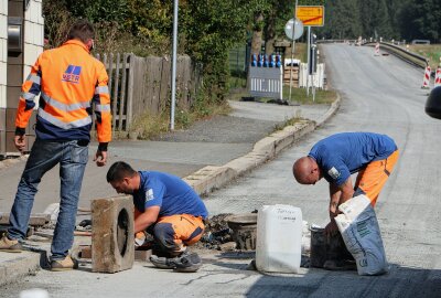 Keine Durchfahrt möglich: Viel befahrene Bundesstraße im Vogtland ist voll gesperrt - Mitarbeiter einer Rodewischer Baufirma bei Arbeiten an einem der Schachtdeckel.. Foto: Simone Zeh