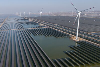 Klimakrise spitzt sich zu - Welche Rolle spielt Deutschland? - Windräder drehen sich auf einem riesigen Solarpark in China. (Archivbild)