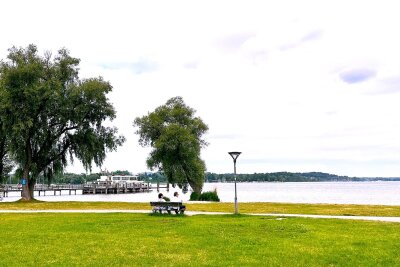 Klischees in tollen Kulissen: Der Bodensee-Königssee-Radweg - Liegen und entspannen in der Pause: Dazu bietet sich etwa der Chiemseestrand bei Felden an.