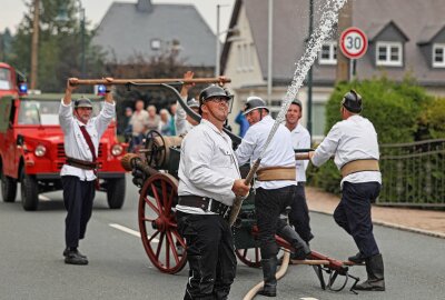 Krachender Auftakt zur Grünbacher Kirmes - Die Kameraden der Feuerwehr Hohenstein-Ernstthal waren zum Umzug mit einer historischen Feuerspritze unterwegs. Foto: Thomas Voigt