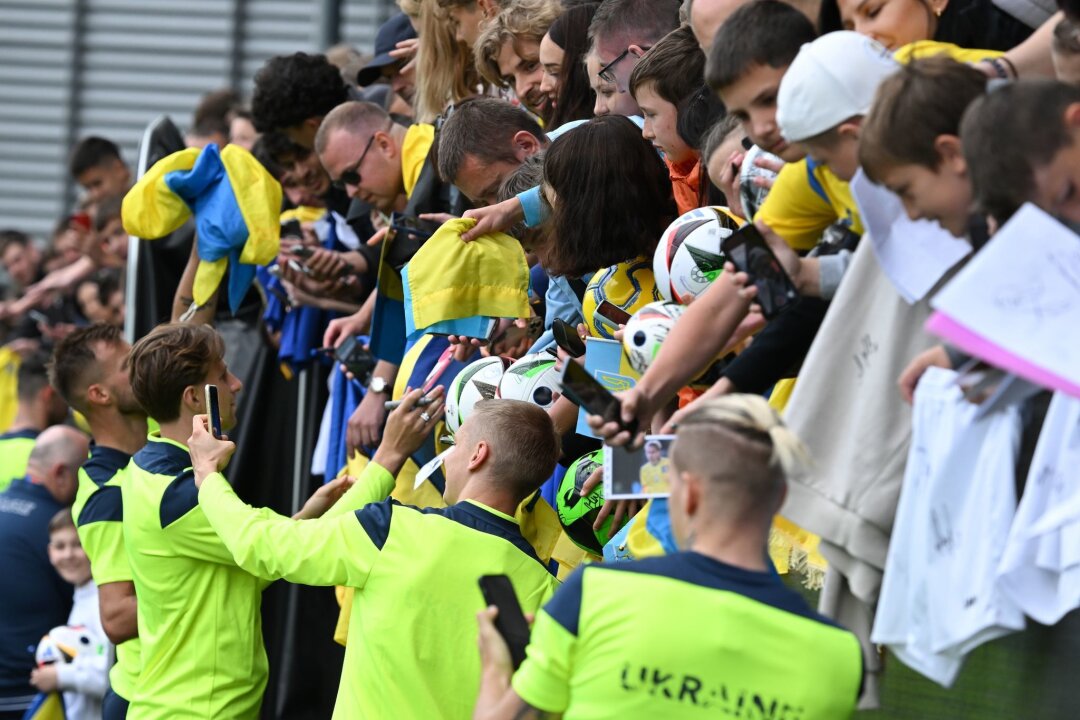 Krieg als "zusätzliche Motivation": Die Ukraine bei der EM - Die ukrainischen Nationalspieler geben nach dem öffentlichen Training Autogramme.