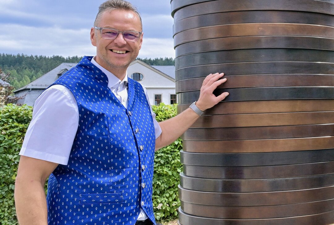 Kunst- und Skulpturenweg "Purple Path": "Coin Stack" steht in Schneeberg - Schneebergs Bürgermeister Ingo Seifert am Kunstwerk "Coin Stack" auf dem Kirchplatz. Foto: Ralf Wendland