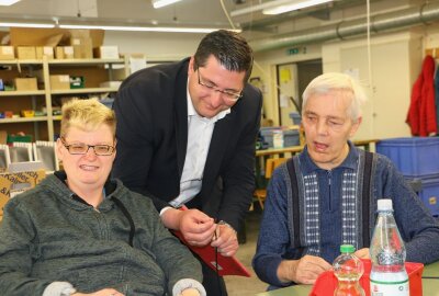 Lebenshilfe Reichenbach will neue Werkstatt bauen - Landrat Thomas Hennig unterhält sich mit Daniel Conrad (links) und Ralf Riedel über ihre Arbeit in der Elektromontage. Foto: Simone Zeh