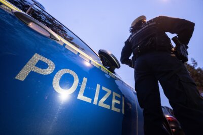 Leblose Person bei Flächensuche in Döbeln gefunden - Eine Polizistin steht neben einem Polizeifahrzeug.