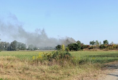 LKW-Trailer brennt auf A14: Dunkle Rauchwolken am Himmel - Der Brand konnte unter schwerem Atemschutz schließlich unter Kontrolle gebracht und ein Übergreifen auf die Zugmaschine verhindert werden. Foto: Sören Müller