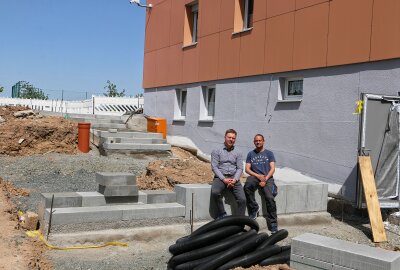 Mensa-Bau in Pausa liegt in letzten Zügen - Statt Bänke gibt es Sitzstufen, Michael Pohl und Frank Schneider, einer der Hausmeister, machen es vor. Foto: Simone Zeh